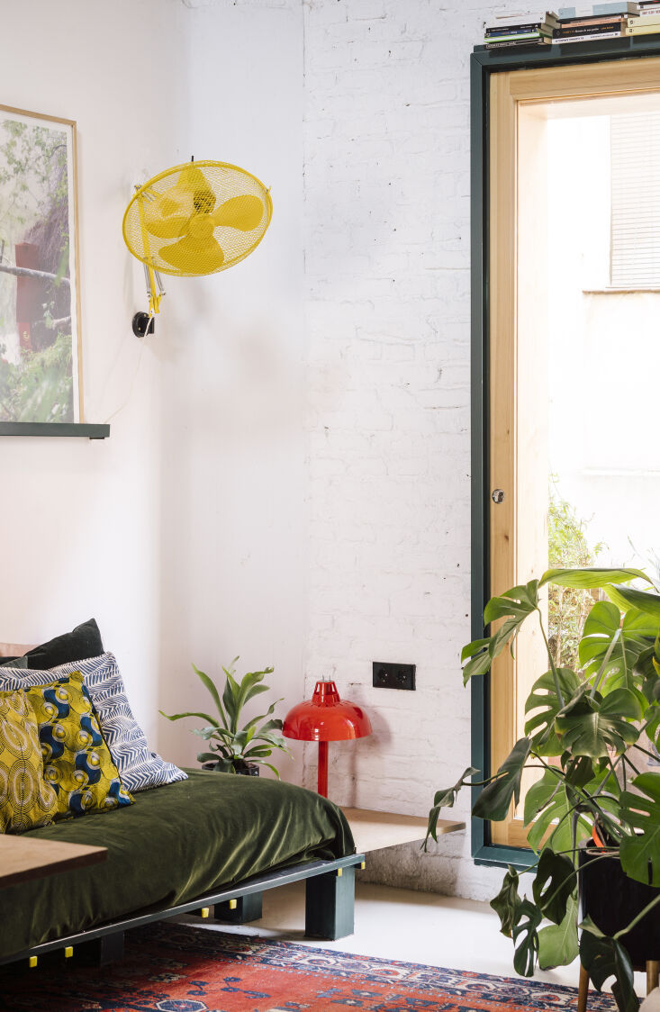 a balcony with sliding glass doors opens up the space. the yellow metal fan is  22