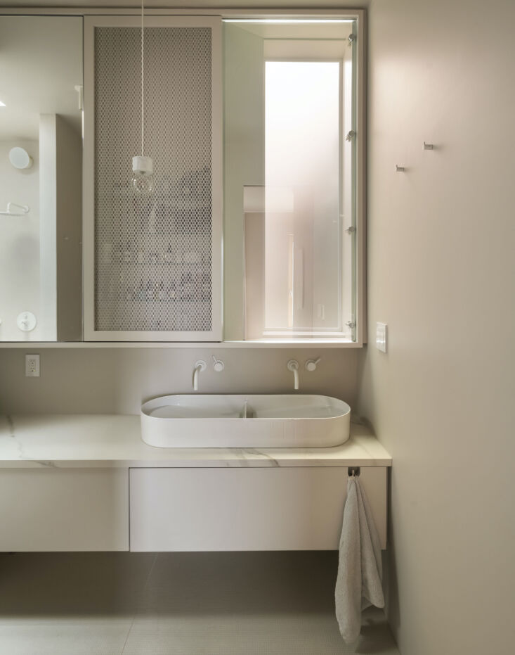the main bath abuts the light well. to make it work studio oink inserted a pane 33