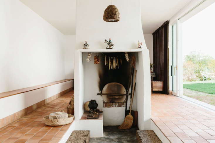 the kitchen has a traditional woodstove. the dark cork pendant light is by the  22