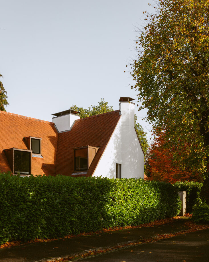 the steeply pitched roof, white gables, and the two capped chimneys are the onl 17