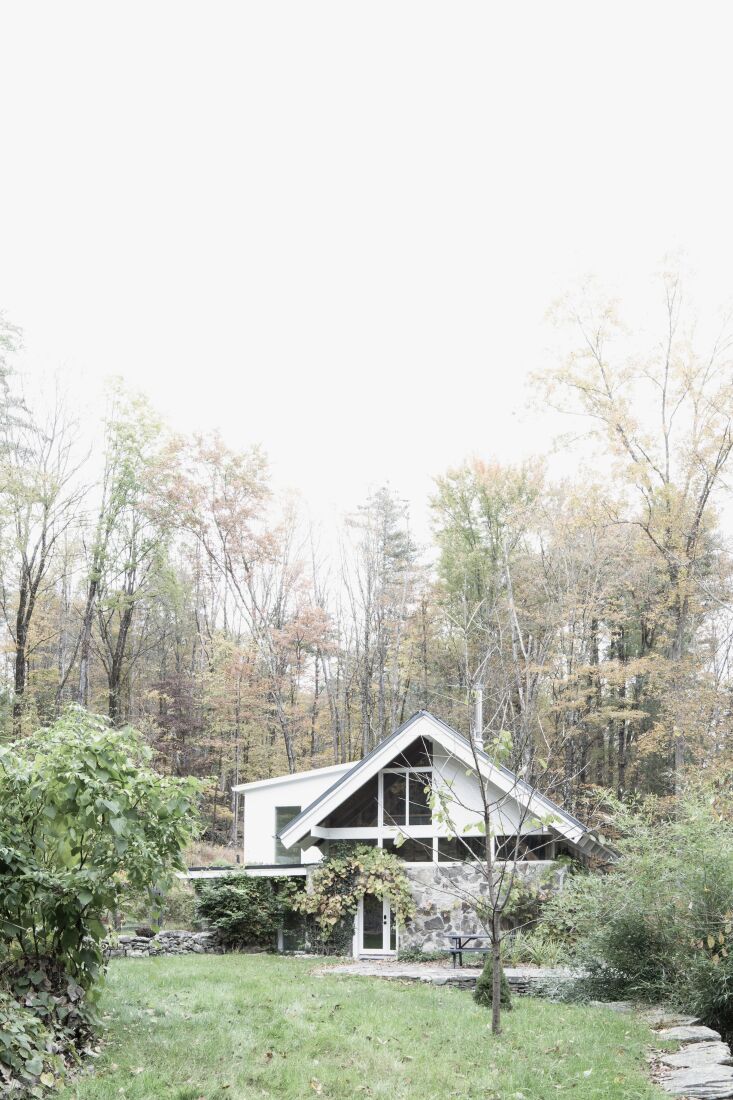 the partly stone modernist house is nestled into a woodland at the foot of the  17