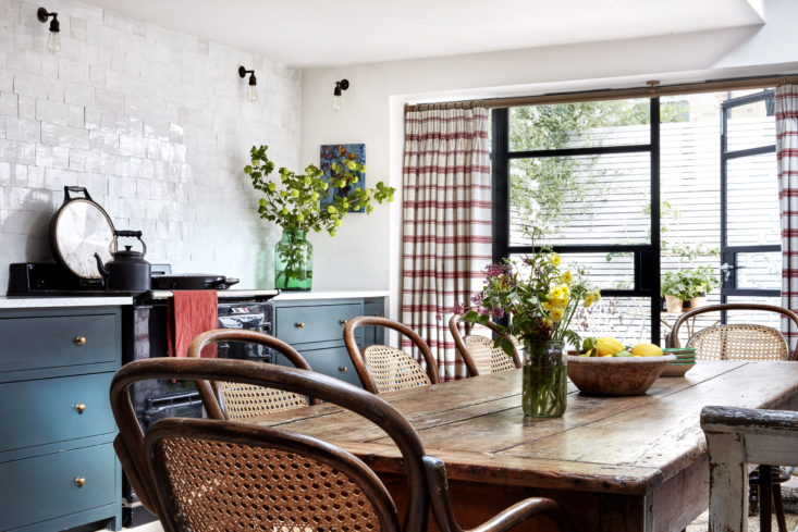 a farmhouse table extends across the kitchen, which the previous owners enlarge 20