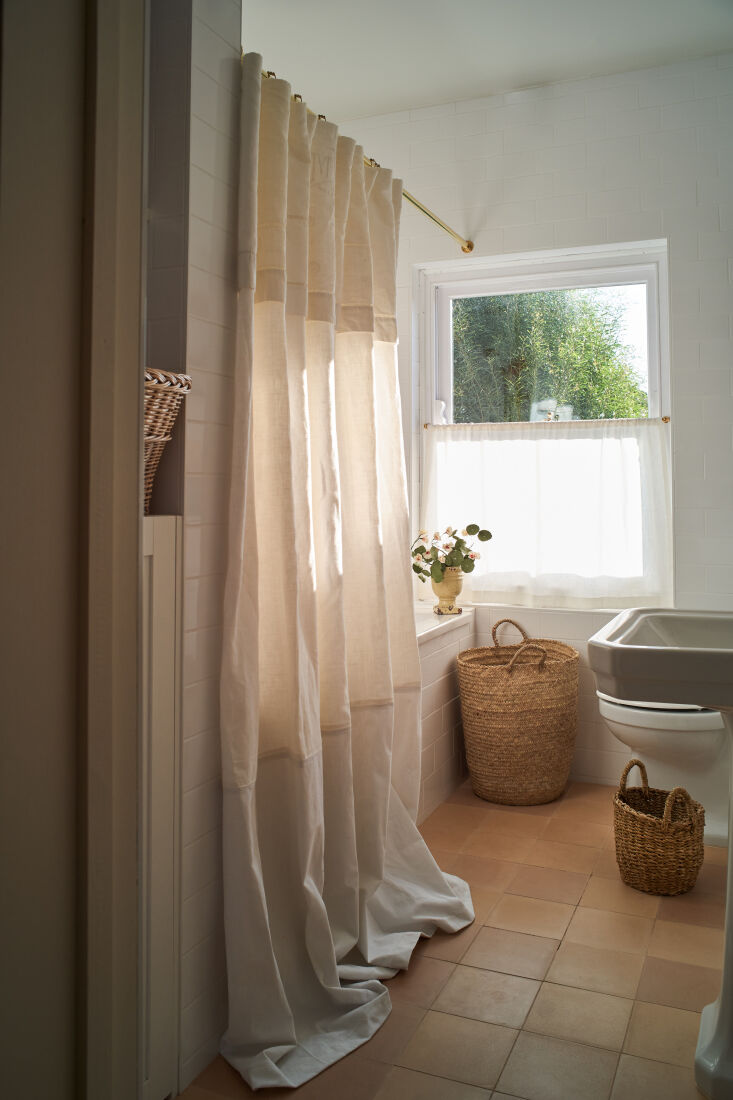the previous bathroom was sleek and modern. sophie softened it with terracotta  23