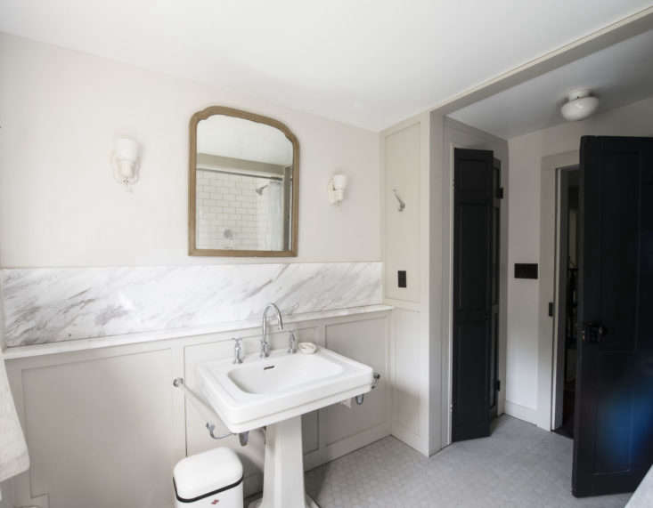 the bathroom is anchored by a vintage porcelain pedestal sink. walls are paint 17